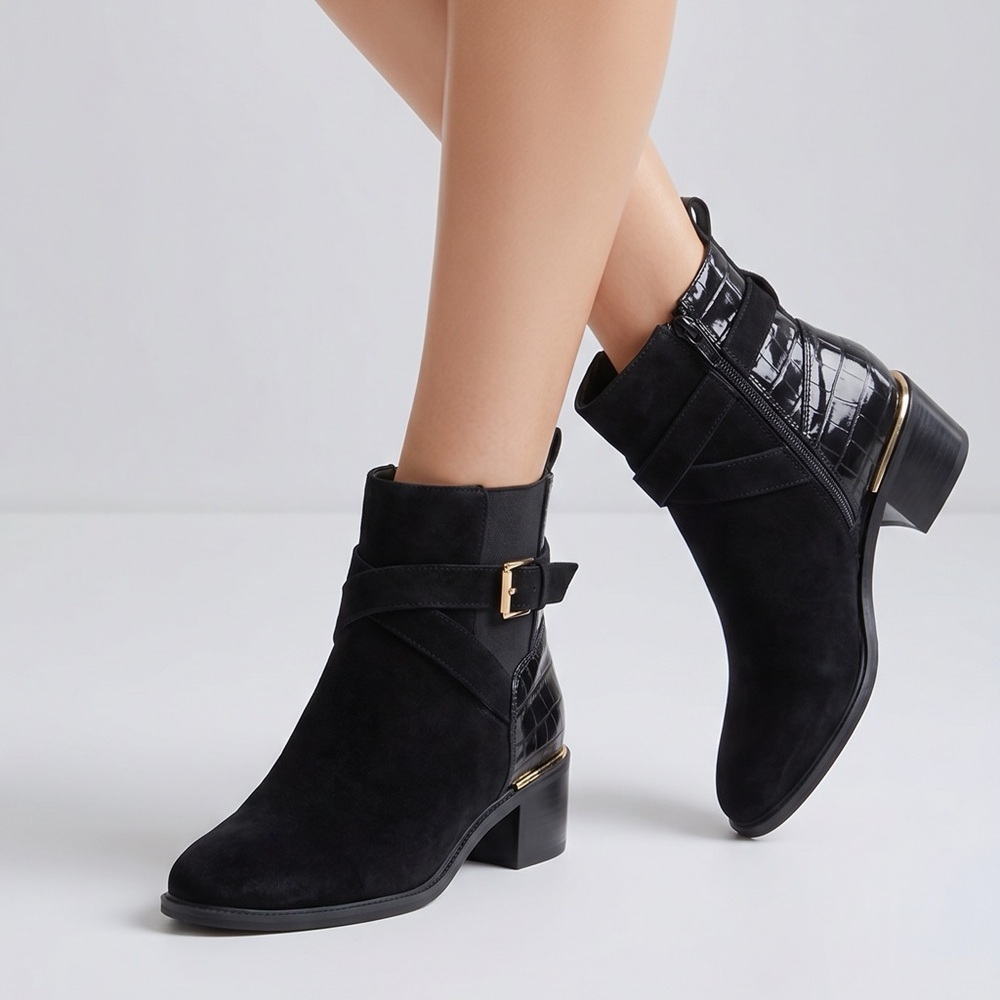 black ankle boot with a block heel and a gold buckle detail